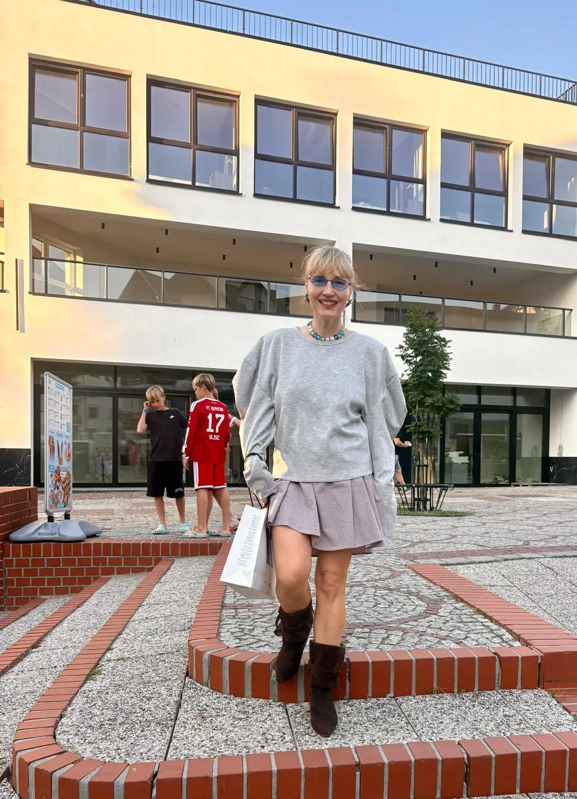 Miejska stylizacja z szarym swetrem, spódnicą i kozakami
